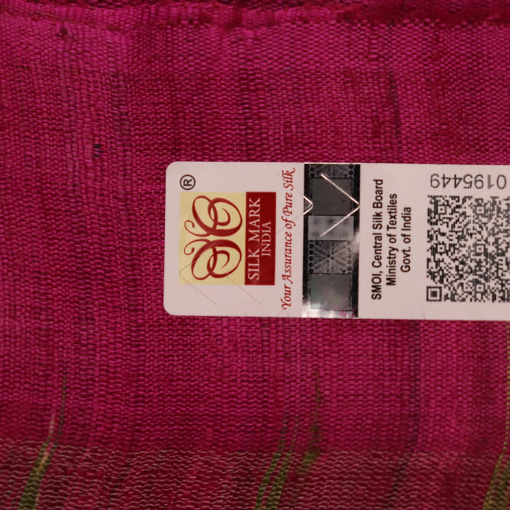 Close-up view of the luxurious texture of a plain green Tussar silk saree with a magenta border