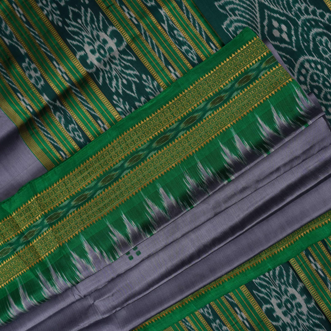 Model draped in a grey and green Khandua silk saree with butta pattern for a classic traditional look.