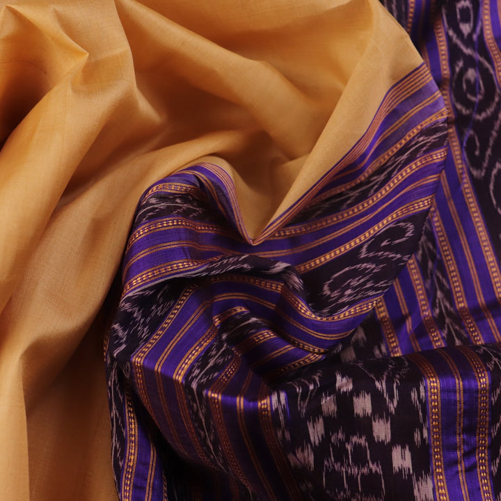 Woman draped in a cream and blue Khandua silk saree with butta pattern, showcasing the elegant drape and styling.