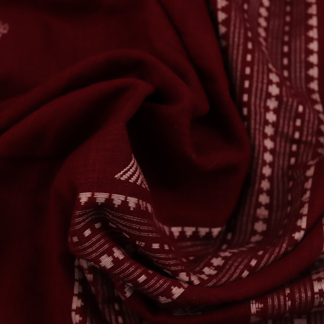 Full view of a maroon and off-white cotton Kotpad saree adorned with a traditional butta pattern.