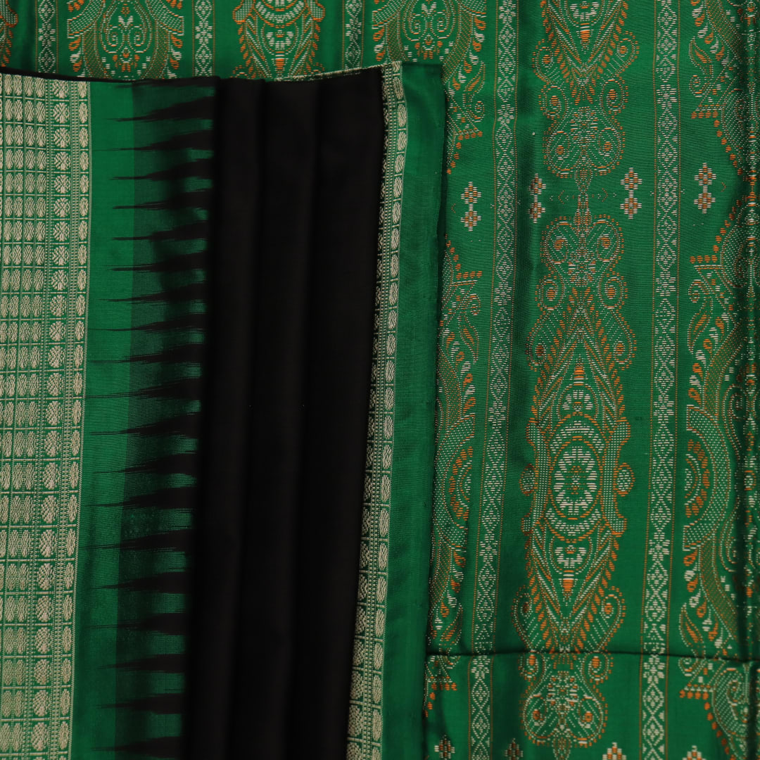 Close-up view of black silk Bomkai saree, showcasing intricate butta patterns and green accents