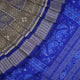 Extreme close-up of the grey and blue Sambalpuri silk saree fabric, revealing its rich texture and intricate weave.