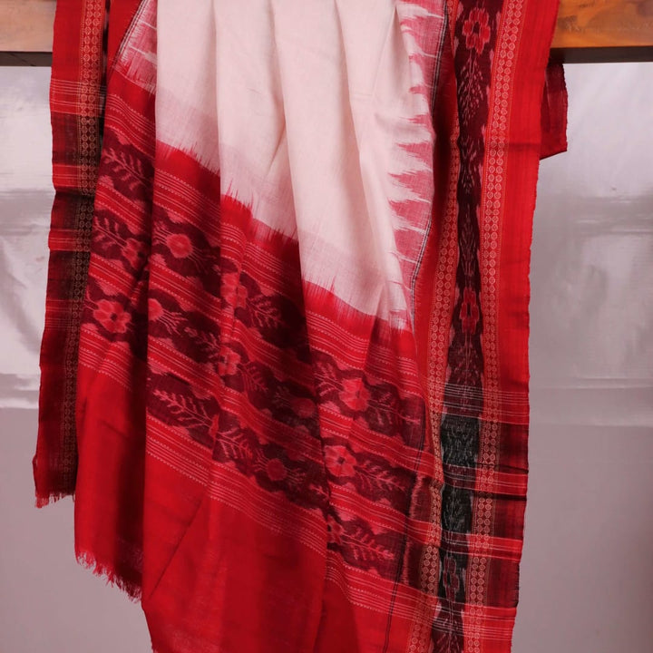 A woman wearing a white and red Sambalpuri cotton dupatta with a plain pattern, draped over her shoulder