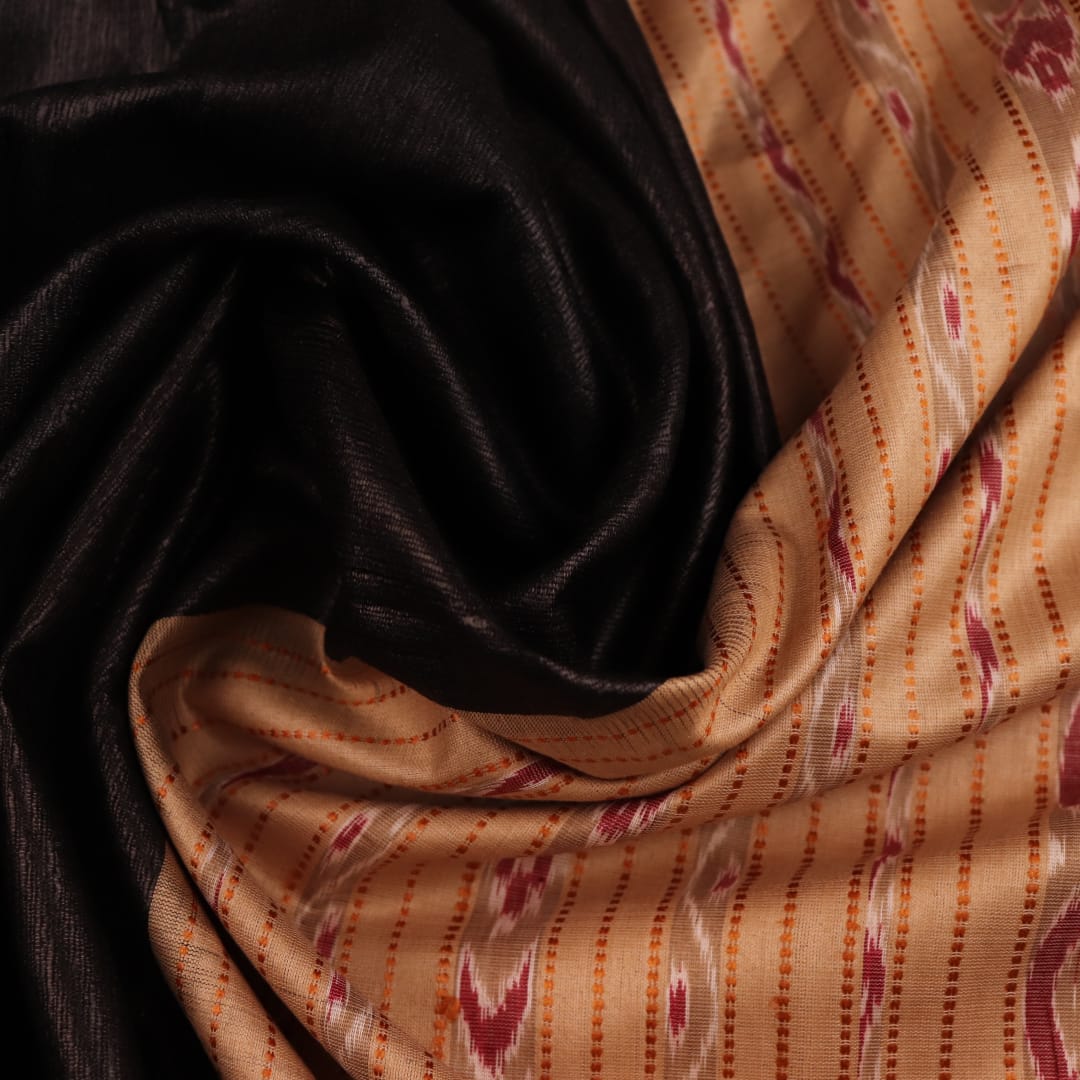 Close-up of black and cream tussar silk sari fabric showing the plain texture.