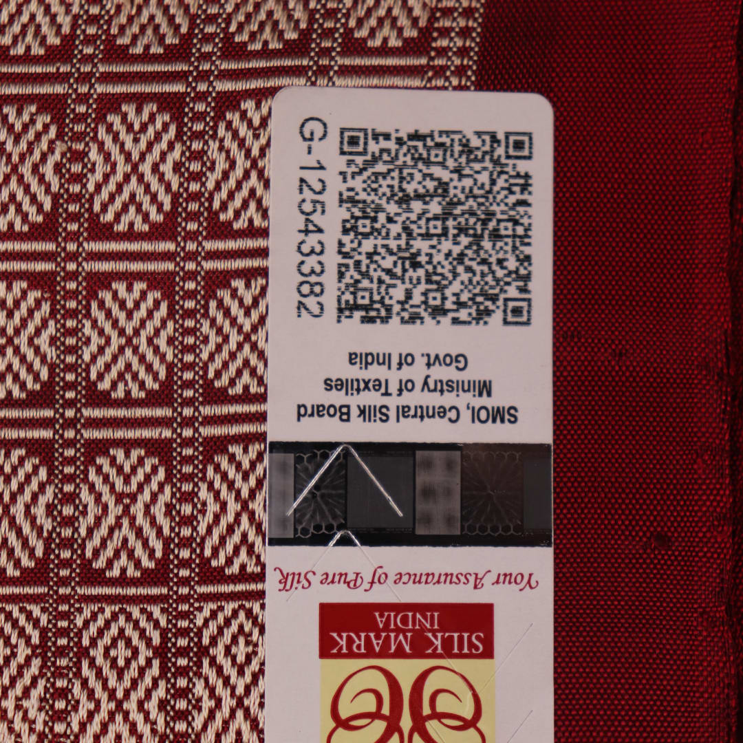 Close-up of multicolored Sambalpuri silk saree fabric texture showing intricate weave and maroon accents.