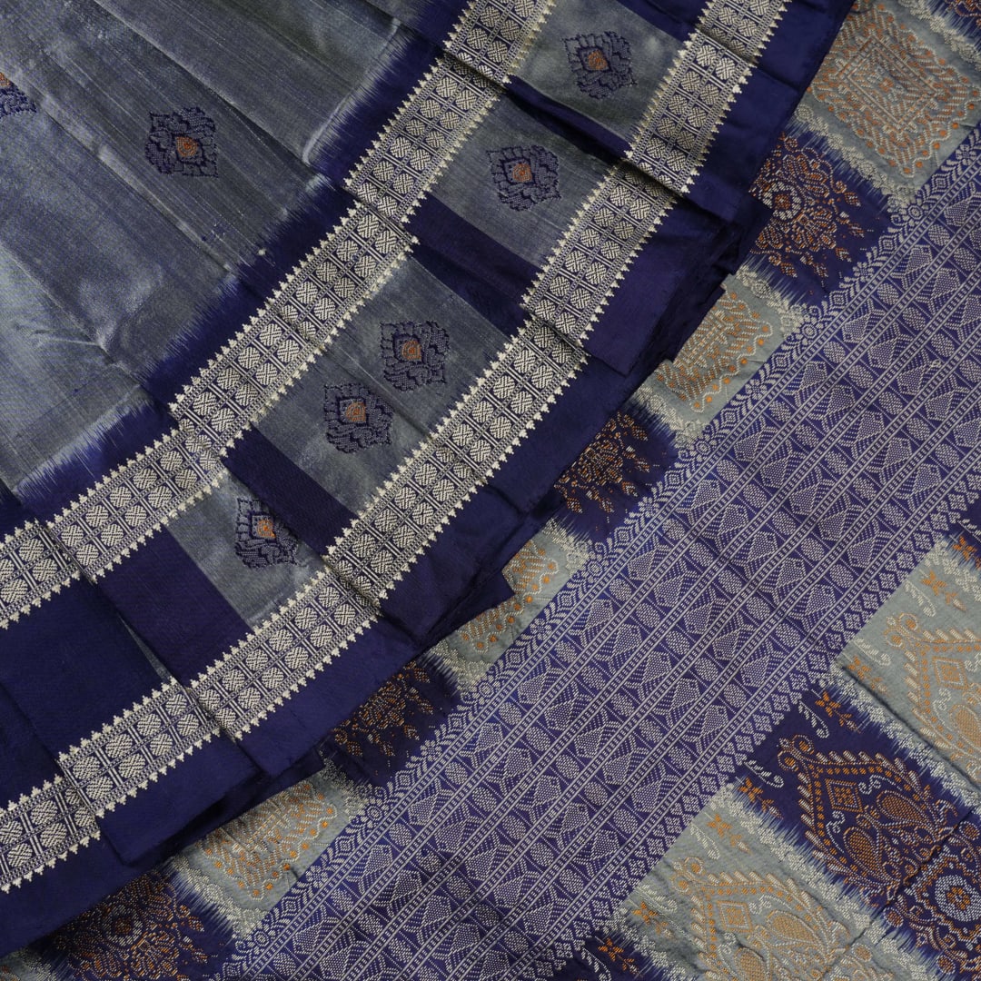 Close-up of luxurious Bomkai Silk Saree fabric texture, highlighting grey and blue handloom weave.