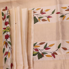 Close-up of off-white printed Tussar Silk saree fabric texture.