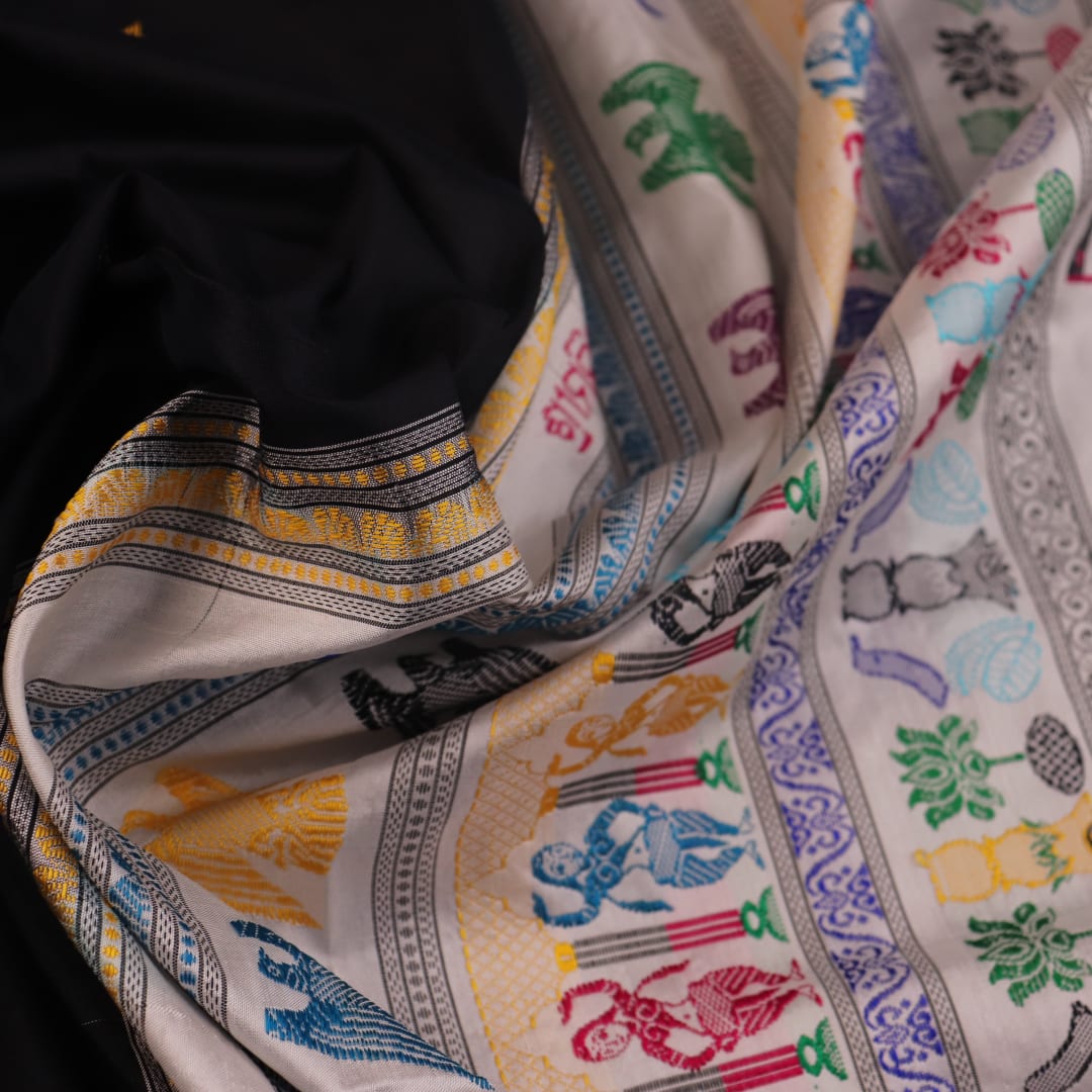 Close-up texture of black and white Bomkai silk saree with butta pattern.