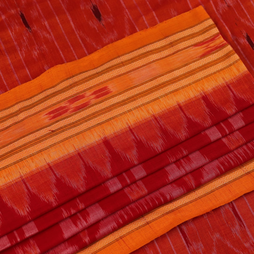 Red and yellow Sambalpuri cotton saree with motifs, elegantly draped to showcase its style.