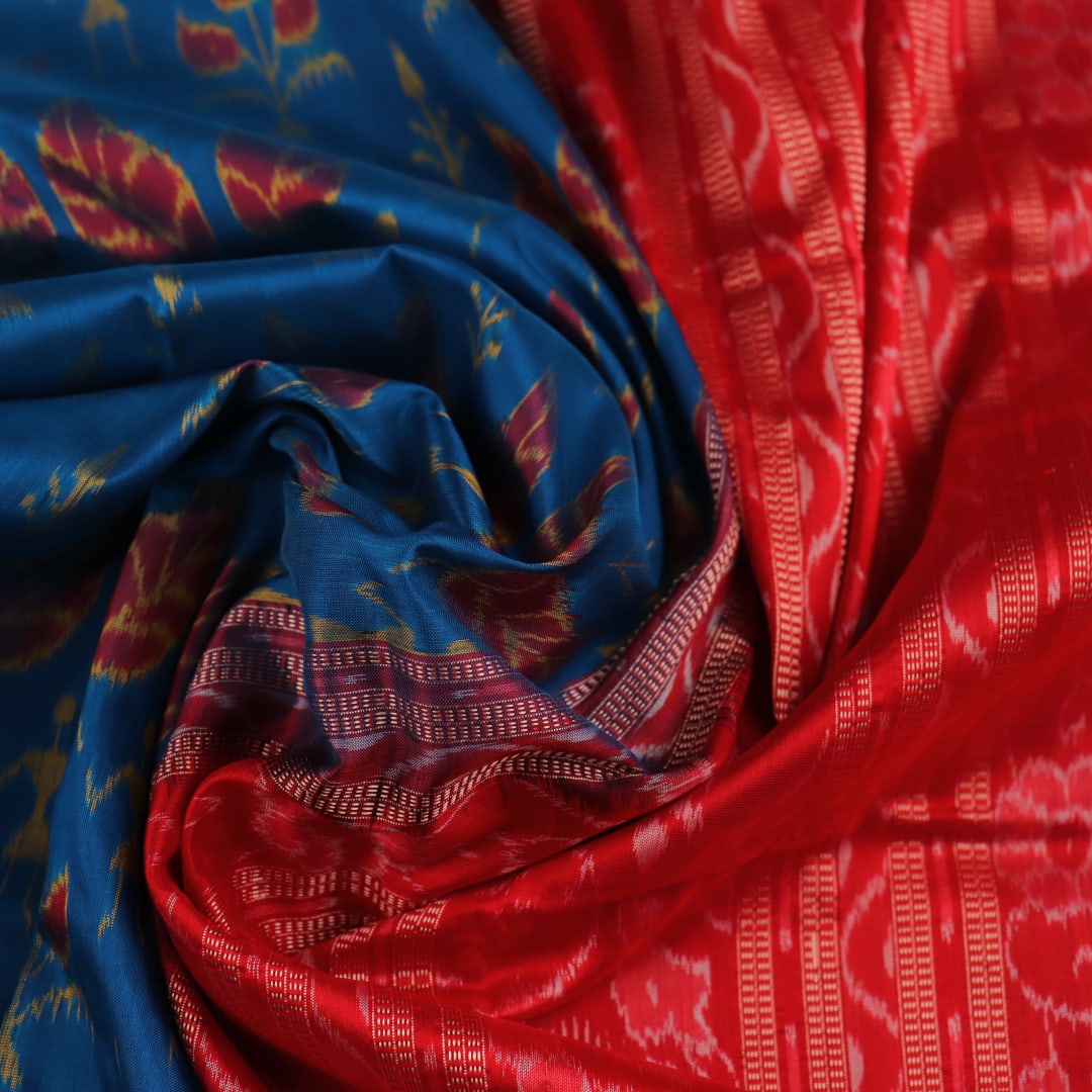 Close-up of blue and orange silk fabric texture with woven motifs