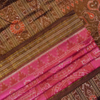 Close-up of Sambalpuri silk fabric texture, highlighting the fine weave in pink and maroon with delicate tissue motifs.