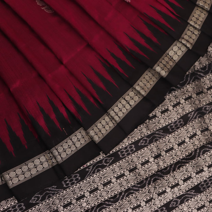 Close-up of magenta and black Bomkai silk saree texture, showing butta pattern weave.