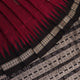 Close-up of magenta and black Bomkai silk saree texture, showing butta pattern weave.