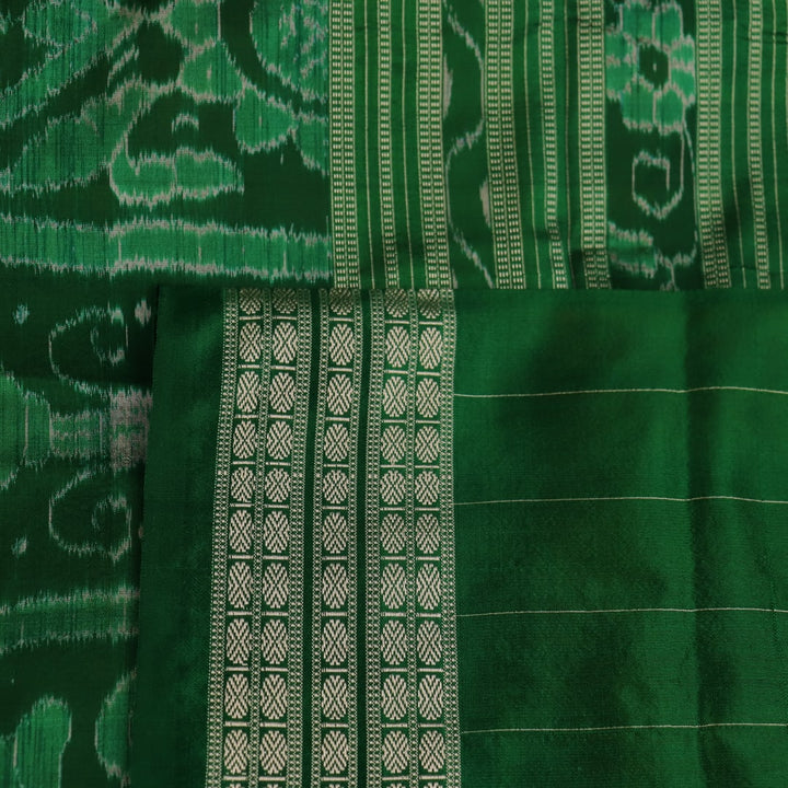 Close-up of yellow Sambalpuri silk saree fabric showing intricate motifs and woven texture.