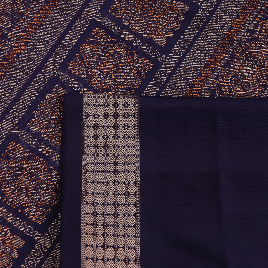 Close-up view of soft, lustrous silk fabric with intricate butta patterns in pink and blue