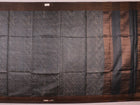 Close-up of the natural slub texture of grey printed Tussar silk saree fabric.