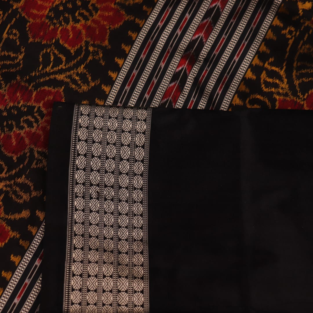 Close-up of intricate motifs on a maroon Sambalpuri silk saree