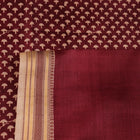 Close-up of maroon Tussar silk saree fabric, showing natural slub texture and printed pattern.