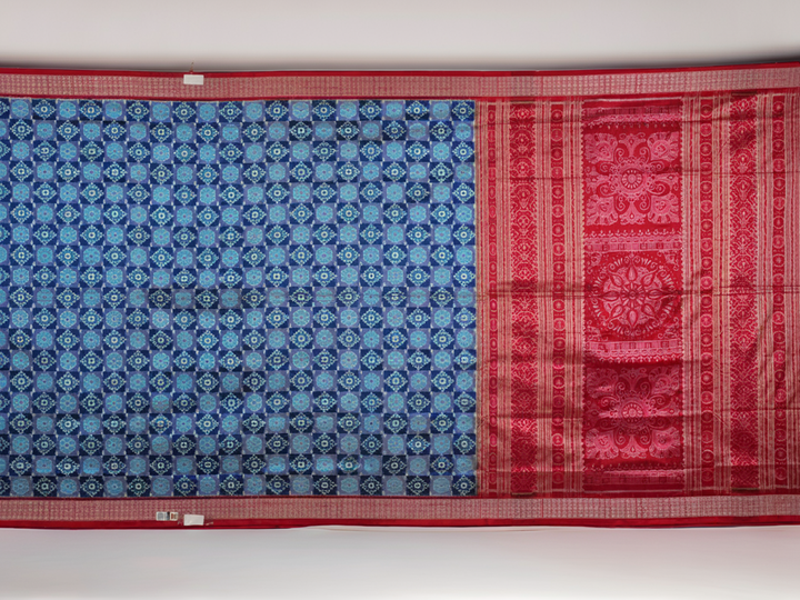 Close-up of the luxurious silk fabric texture and distinctive Sambalpuri ikat weave of the blue Pasapalli saree.