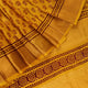 Close-up of the yellow printed Tussar silk saree's distinct slubby fabric texture.