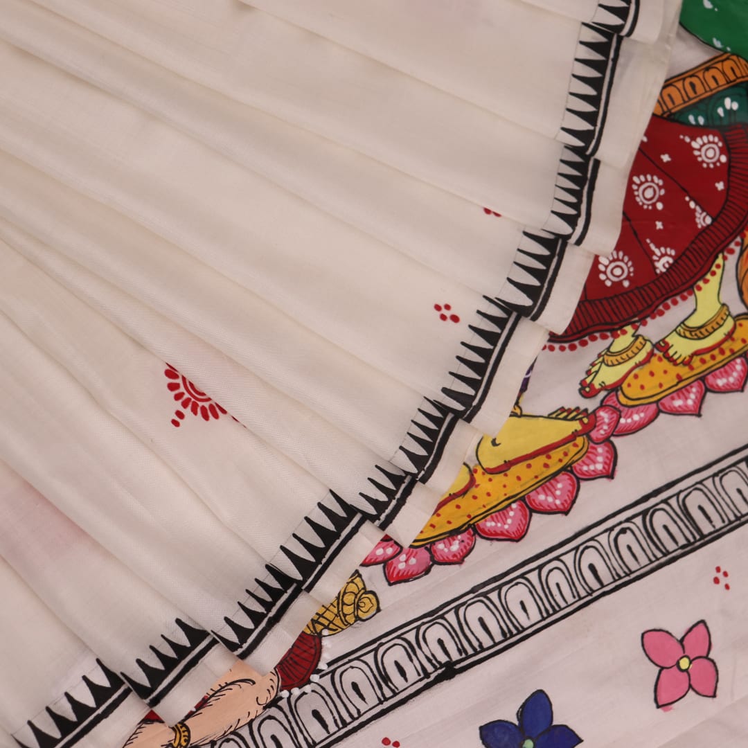 Close-up of handloom white silk Patachitra saree fabric showing texture and hand-painted details.