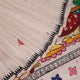 Close-up of handloom white silk Patachitra saree fabric showing texture and hand-painted details.