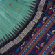 Extreme close-up revealing the rich texture and intricate weave of green Bomkai Silk fabric.