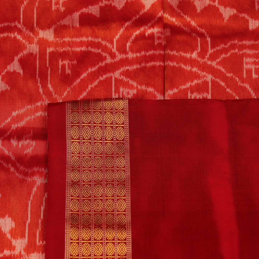 Close-up of white and red silk Bomkai saree fabric texture with butta pattern.