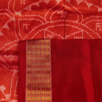 Close-up of white and red silk Bomkai saree fabric texture with butta pattern.
