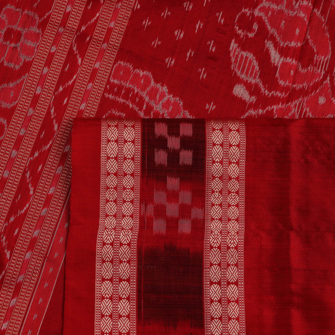 Close-up of black and red silk saree fabric with intricate Sambalpuri motifs