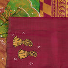 Close-up of magenta Patachitra silk saree fabric texture showing handloom weave and paint details.