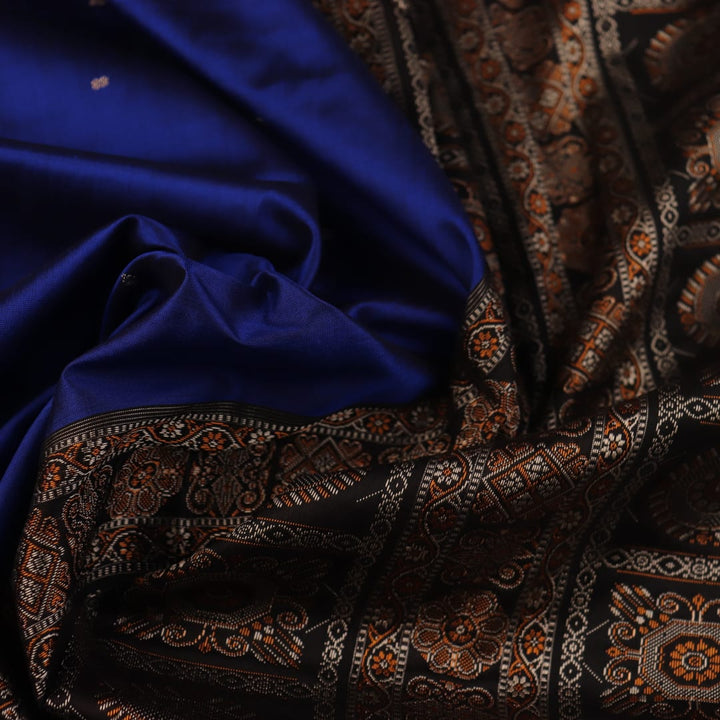 Close-up of the intricate woven texture of blue and black Bomkai silk saree with butta.