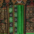 Model draped in a green and black Khandua silk saree with butta work, showcasing elegant ethnic styling.