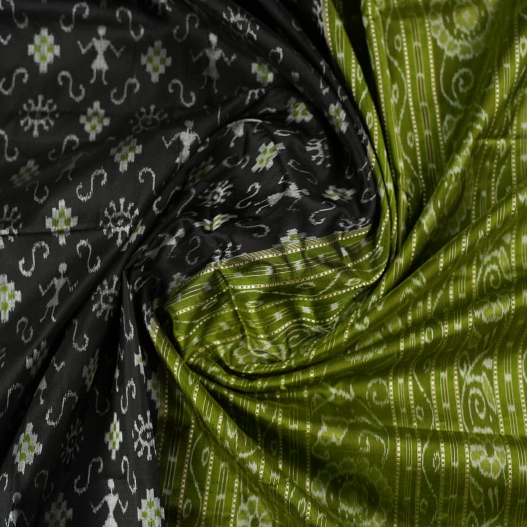 Close-up of the luxurious black and green Sambalpuri silk fabric texture and weave.