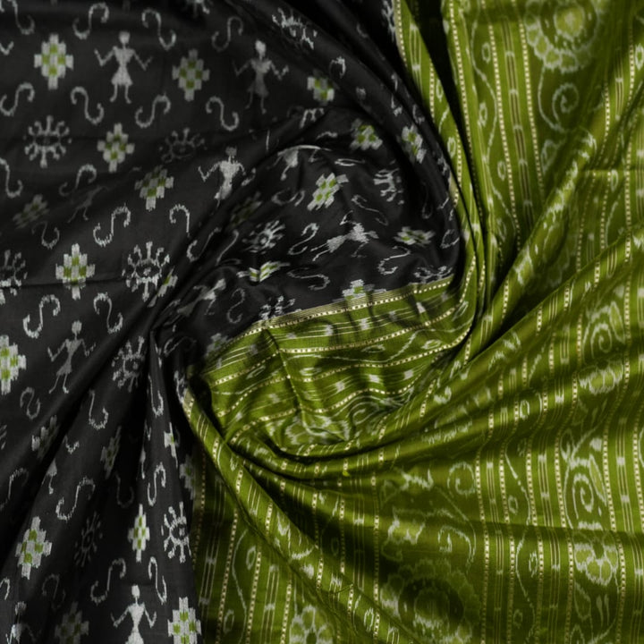 Close-up of the luxurious black and green Sambalpuri silk fabric texture and weave.