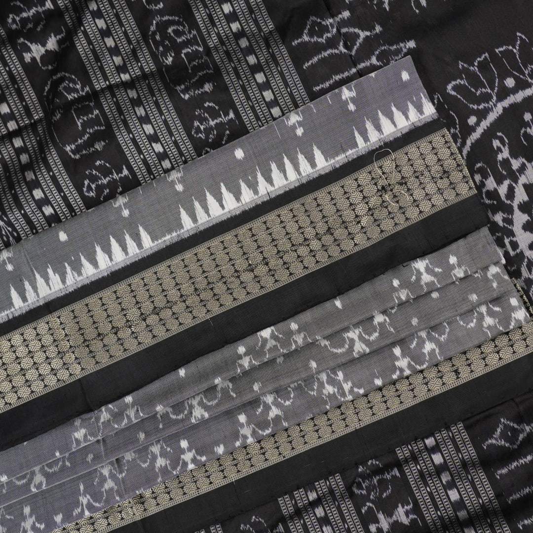 Close-up of grey & black Sambalpuri silk saree fabric, highlighting its rich texture and weave.