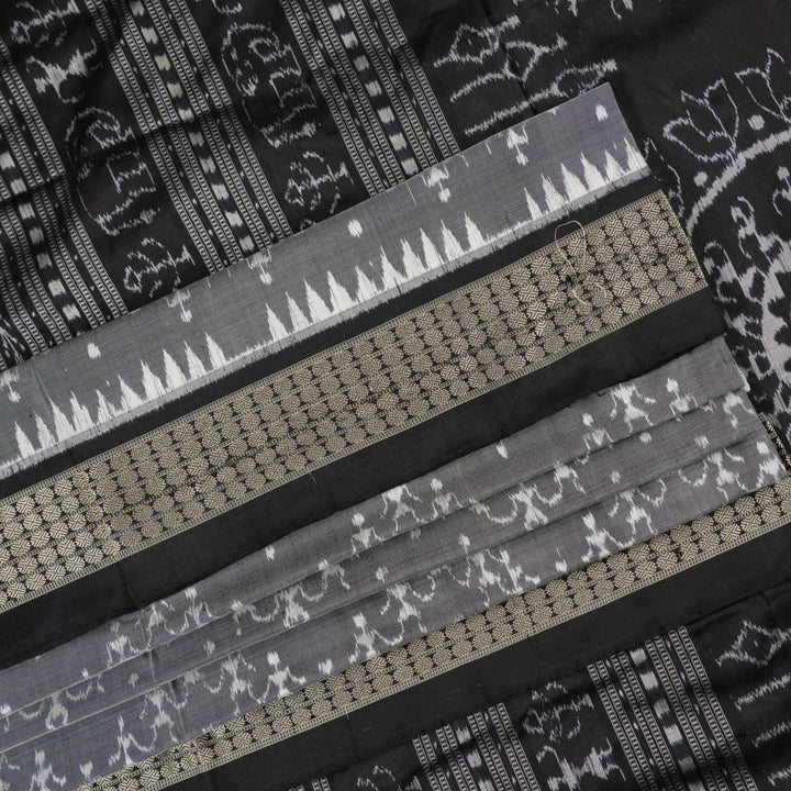Close-up of grey & black Sambalpuri silk saree fabric, highlighting its rich texture and weave.