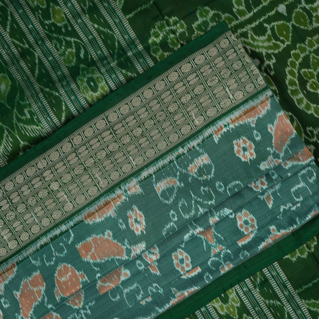 Ultra close-up of green Sambalpuri silk saree fabric, highlighting its luxurious texture and weave.