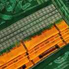 Close-up of yellow Sambalpuri silk saree fabric showing intricate motifs and woven texture.