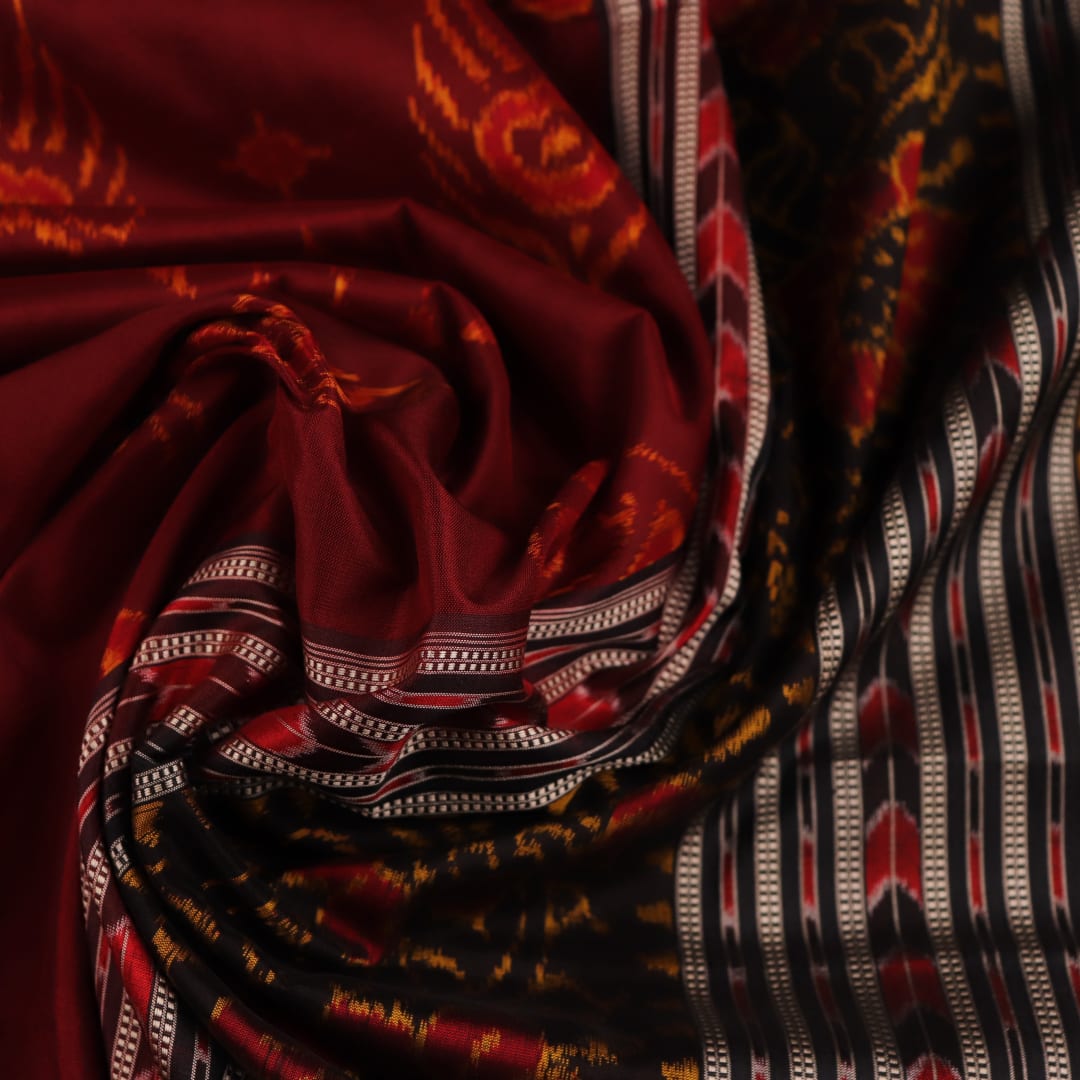 Close-up of intricate motifs on a maroon Sambalpuri silk saree