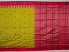 Close-up of green and magenta Bomkai silk saree fabric texture, highlighting intricate weave and butta pattern.