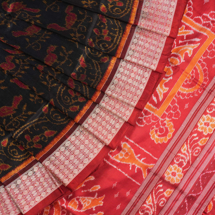 Close-up of Sambalpuri silk fabric texture, highlighting fine handloom weave in black and maroon.