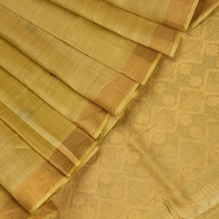 Close-up of yellow Tussar silk saree fabric with intricate butta patterns