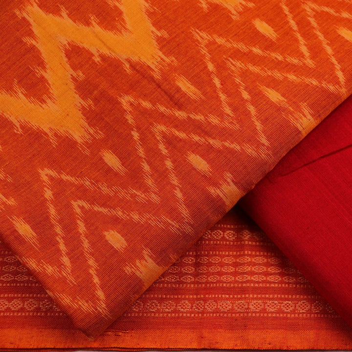 Close-up detail showcasing the traditional motifs in orange and red on cotton Sambalpuri dress material.