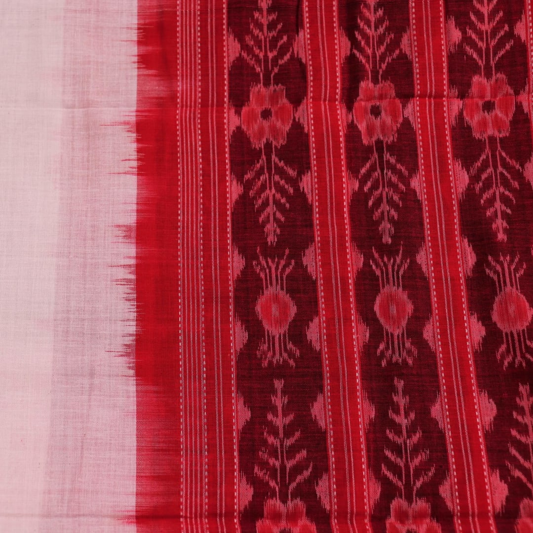 A woman wearing a white and red Sambalpuri cotton dupatta with a plain pattern, draped over her shoulder