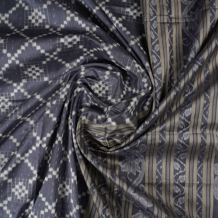 Close-up of the soft, luxurious grey Sambalpuri silk fabric texture with subtle weave details.