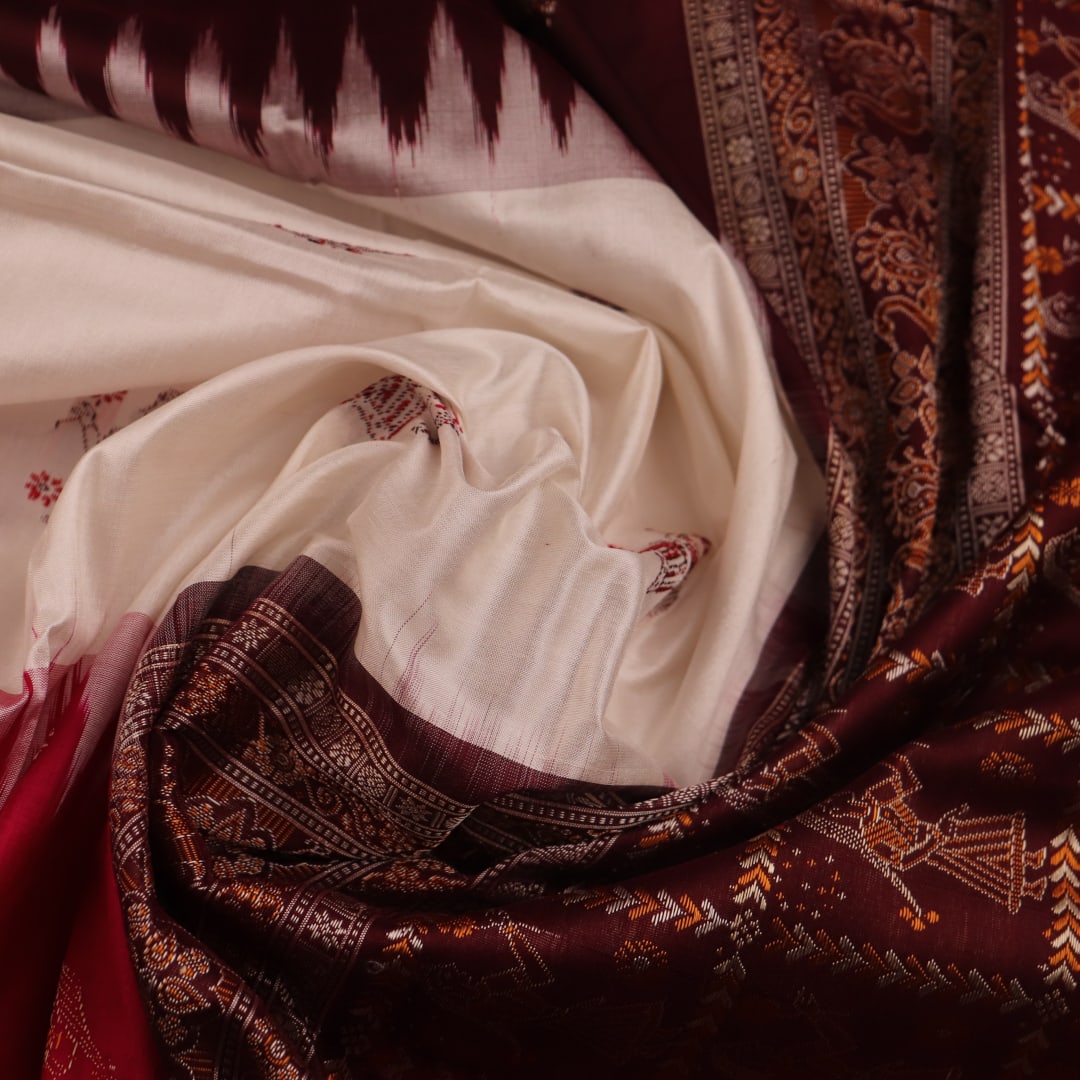 Close-up view of the woven fabric texture, showcasing the intricate butta patterns on the white silk body.