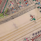 Close-up of the white silk saree fabric texture, showcasing the handloom weave and painted Patachitra details.