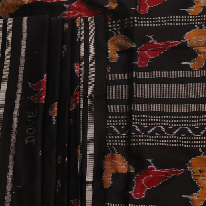 Close-up of the textured silk fabric of a black Sambalpuri saree showing intricate motifs.