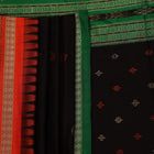 Close-up view of black silk Bomkai saree fabric showcasing its intricate butta pattern.